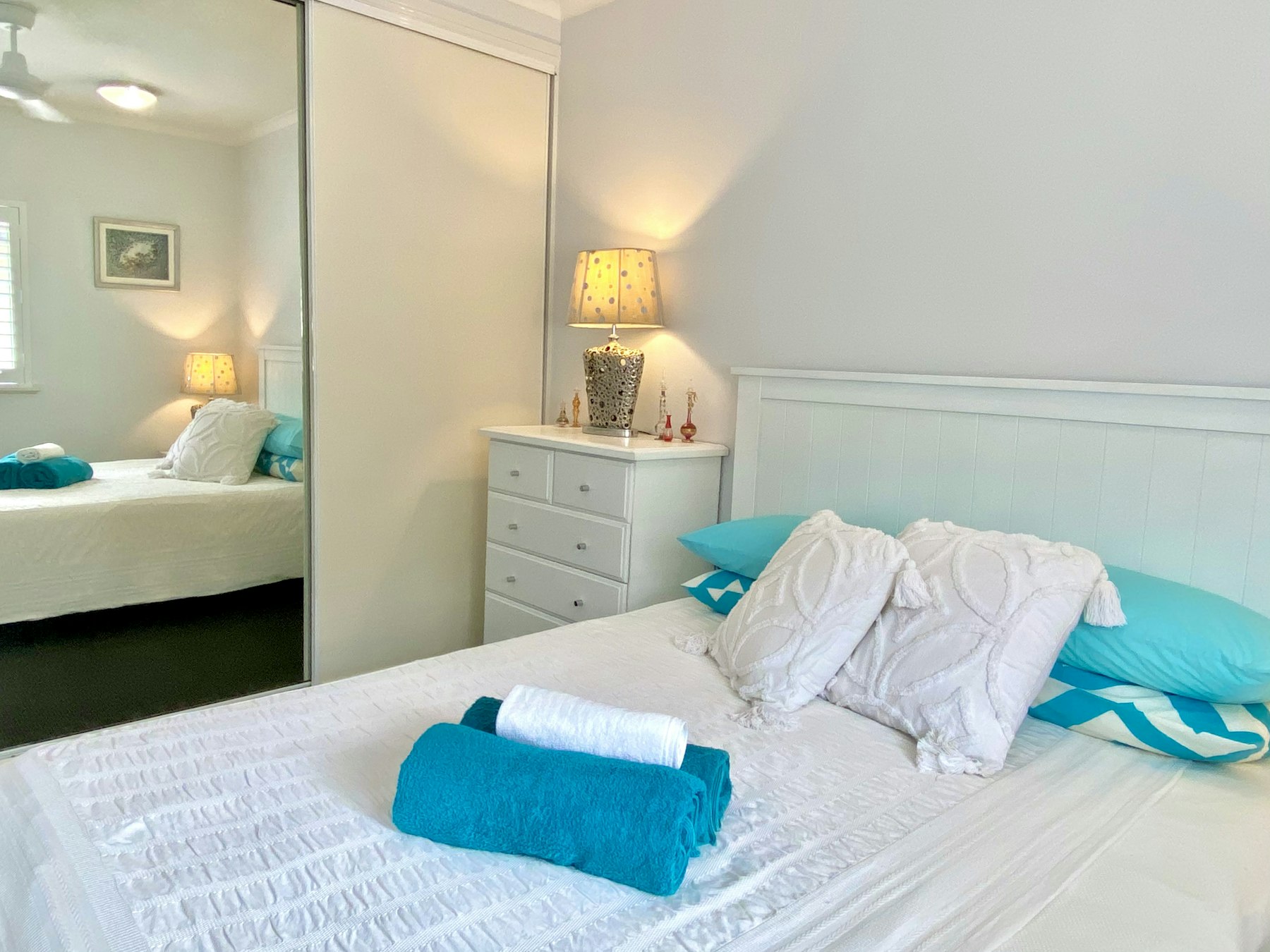 Frisch bezogenes Bett mit gefaltetem Handtuch in einer Ferienwohnung